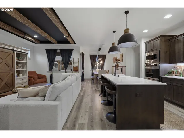 a living room with stainless steel appliances kitchen island granite countertop furniture and a view of kitchen