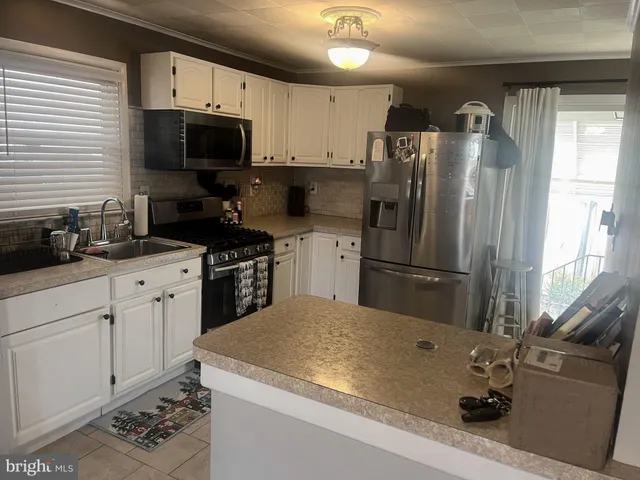a kitchen with a sink stainless steel appliances and white cabinets