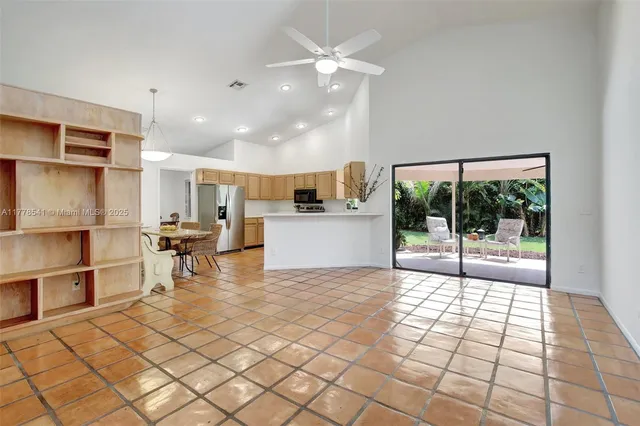a view of a kitchen with kitchen island stainless steel appliances refrigerator sink and cabinets