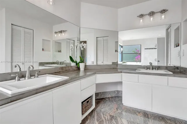 a bathroom with double vanity sinks and a mirror