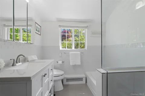 a bathroom with a sink a toilet and a window