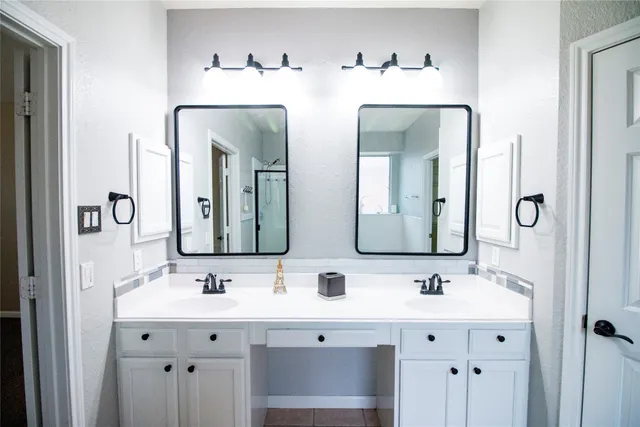 a bathroom with double vanity sinks and a mirror