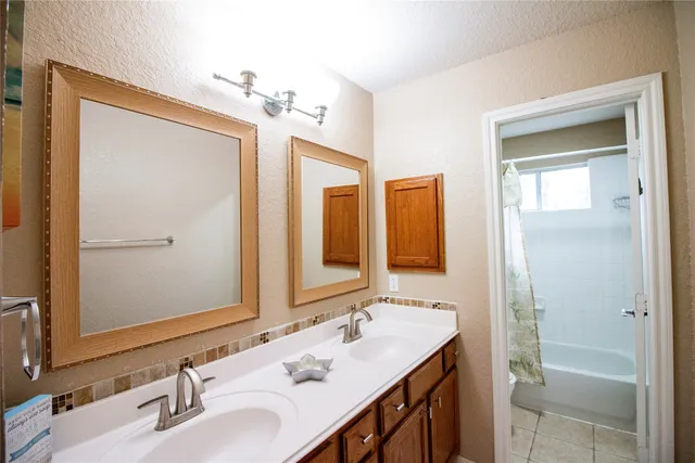 a bathroom with a double vanity sink and a mirror