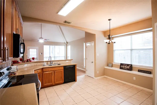 a large kitchen with kitchen island a large counter space a sink stainless steel appliances and cabinets
