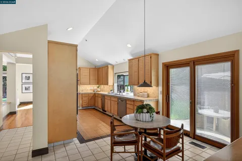 a kitchen with a table chairs refrigerator and cabinets