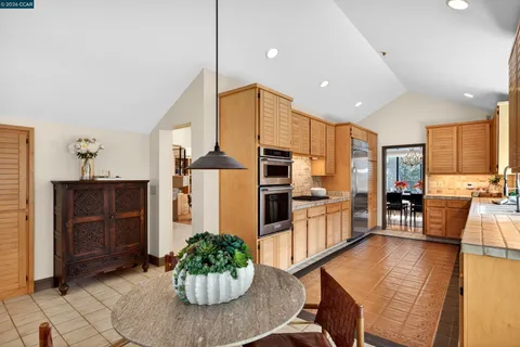 a kitchen with stainless steel appliances kitchen island granite countertop furniture and a refrigerator