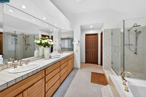 a bathroom with a tub sink and mirror