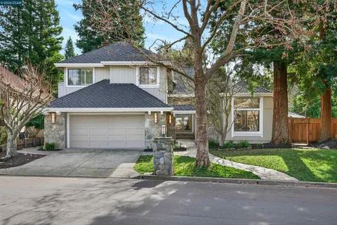 a front view of a house with a garden and plants