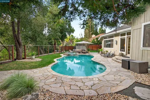 a backyard of a house with fountain table and chairs