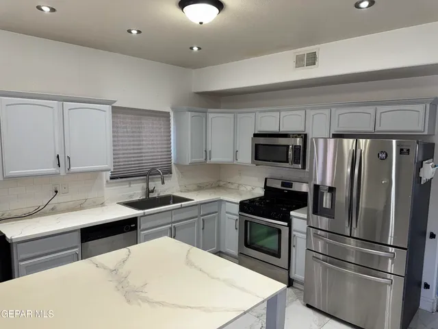 a kitchen with a sink stainless steel appliances and cabinets