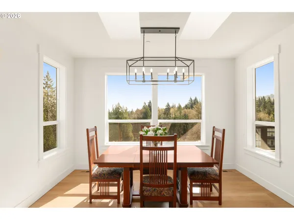 a view of a dining room with furniture a chandelier and wooden floor