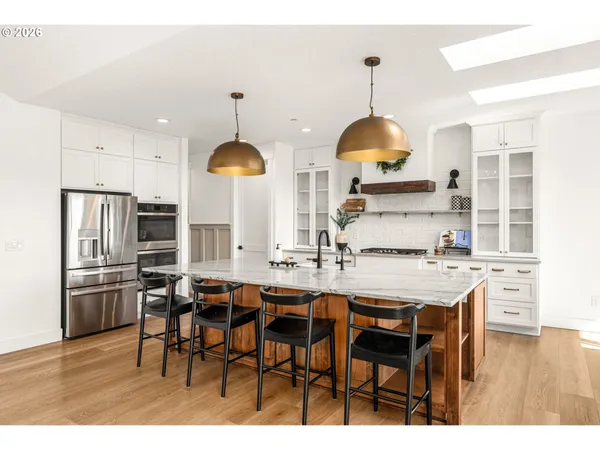 a kitchen with stainless steel appliances a dining table chairs and chandelier