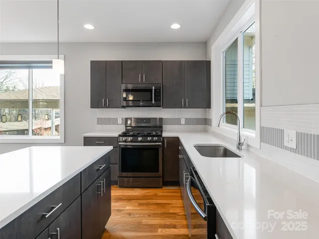 a kitchen with kitchen island a counter top space a sink and appliances