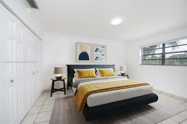 a bed sitting in a bedroom next to a window