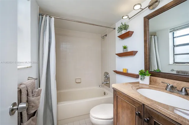 a bathroom with a granite countertop sink a toilet and shower