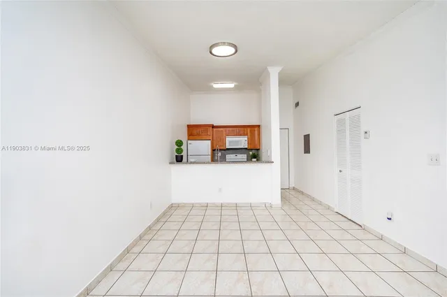a view of a hallway with wooden floor and a large mirror in a room