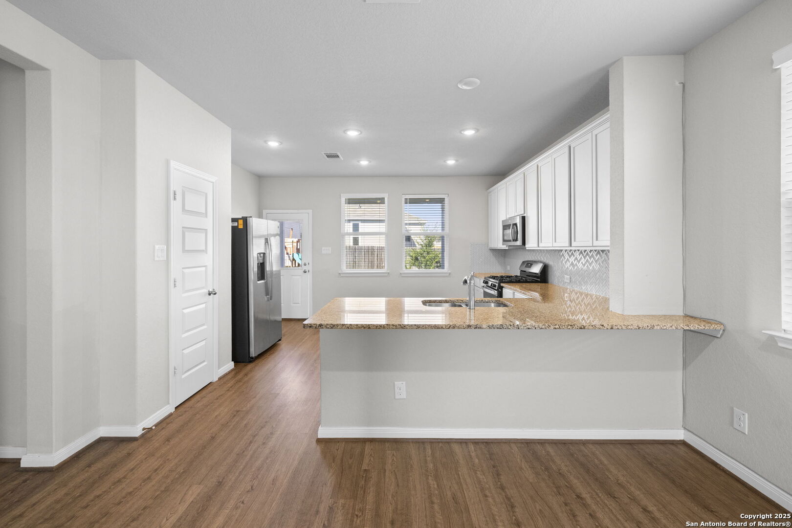 5139 Longhorn Converse, TX 78109 - Photo 16 of 46 a view of a kitchen with kitchen island a sink wooden floor and stainless steel appliances