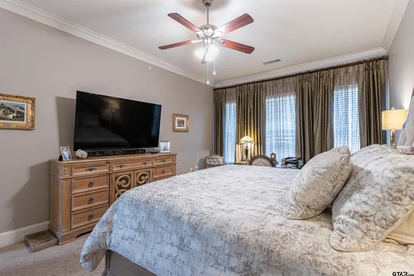 a bedroom with a large bed and a flat screen tv