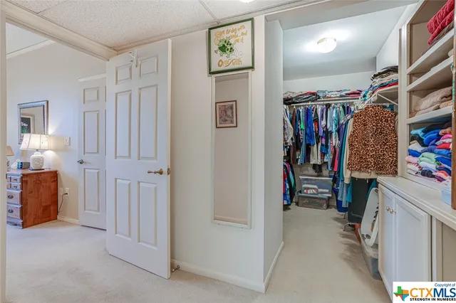 a view of walk in closet with clothes and shoes