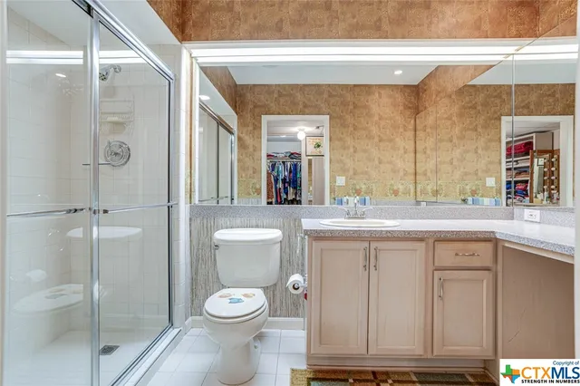 a bathroom with a toilet a sink and glass door