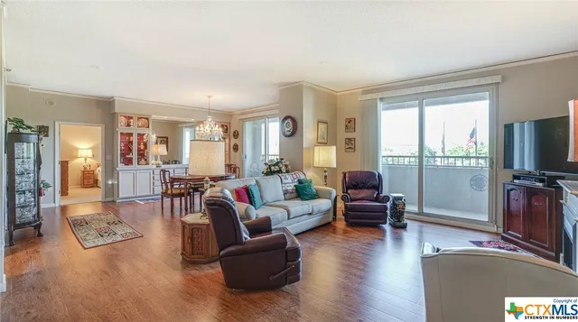 a living room with furniture flat screen tv and a large window