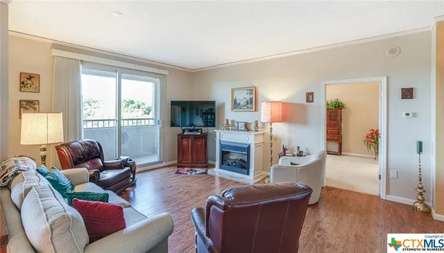 a living room with furniture a flat screen tv and a large window