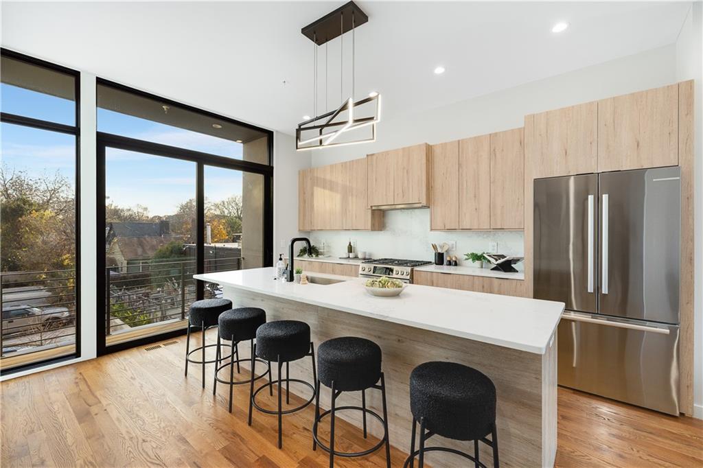 105 Georgia Avenue Southeast, Unit 1 Atlanta, GA 30312 - Photo 4 of 40 a kitchen with stainless steel appliances a dining table chairs and wooden floor