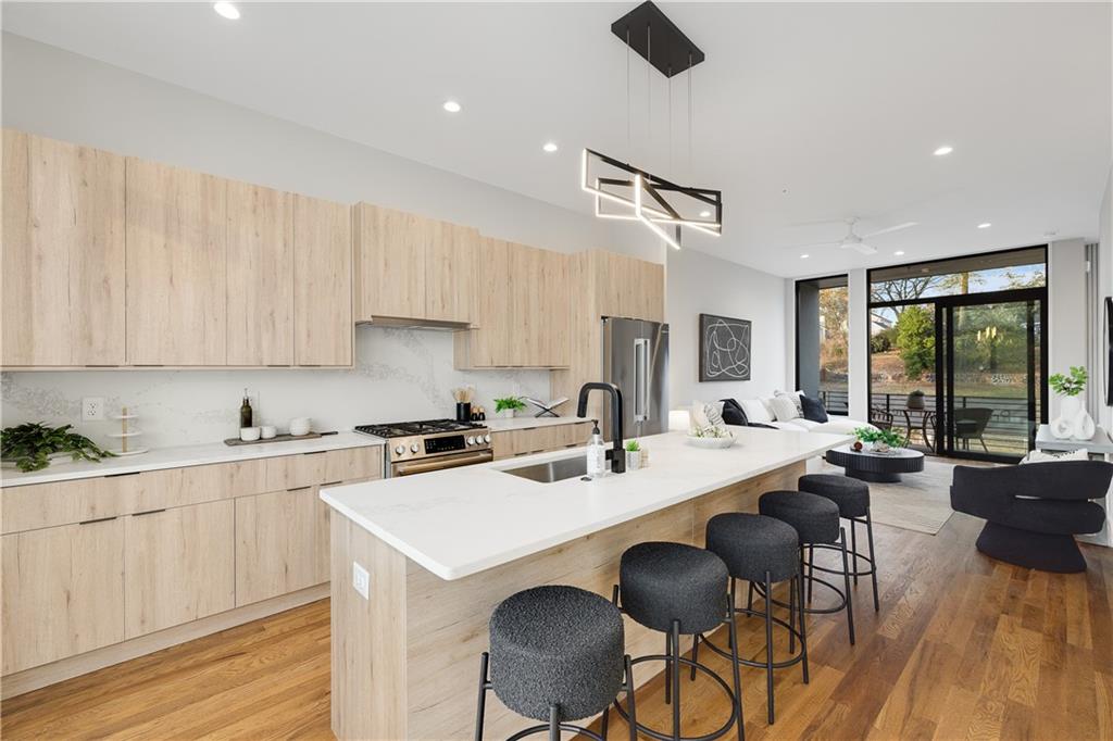 105 Georgia Avenue Southeast, Unit 1 Atlanta, GA 30312 - Photo 5 of 40 a kitchen with a stove a sink a dining table and chairs