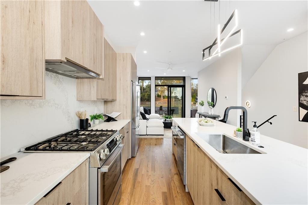 105 Georgia Avenue Southeast, Unit 1 Atlanta, GA 30312 - Photo 9 of 40 a kitchen with a sink a stove and cabinets