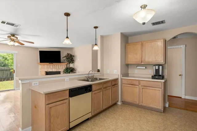 a kitchen with a sink and a stove top oven with wooden floor