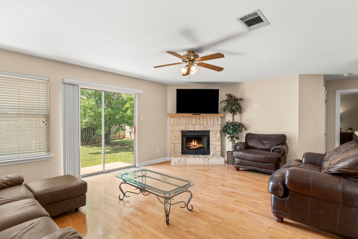141 Sydney's Way Buda, TX 78610 - Photo 14 of 37 a living room with furniture a flat screen tv and a fireplace
