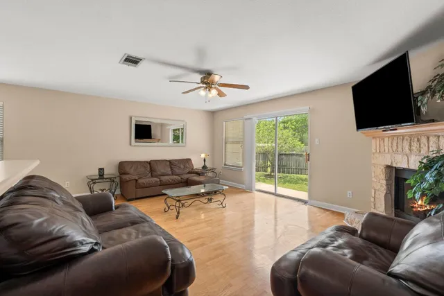 a living room with furniture a flat screen tv and a large window