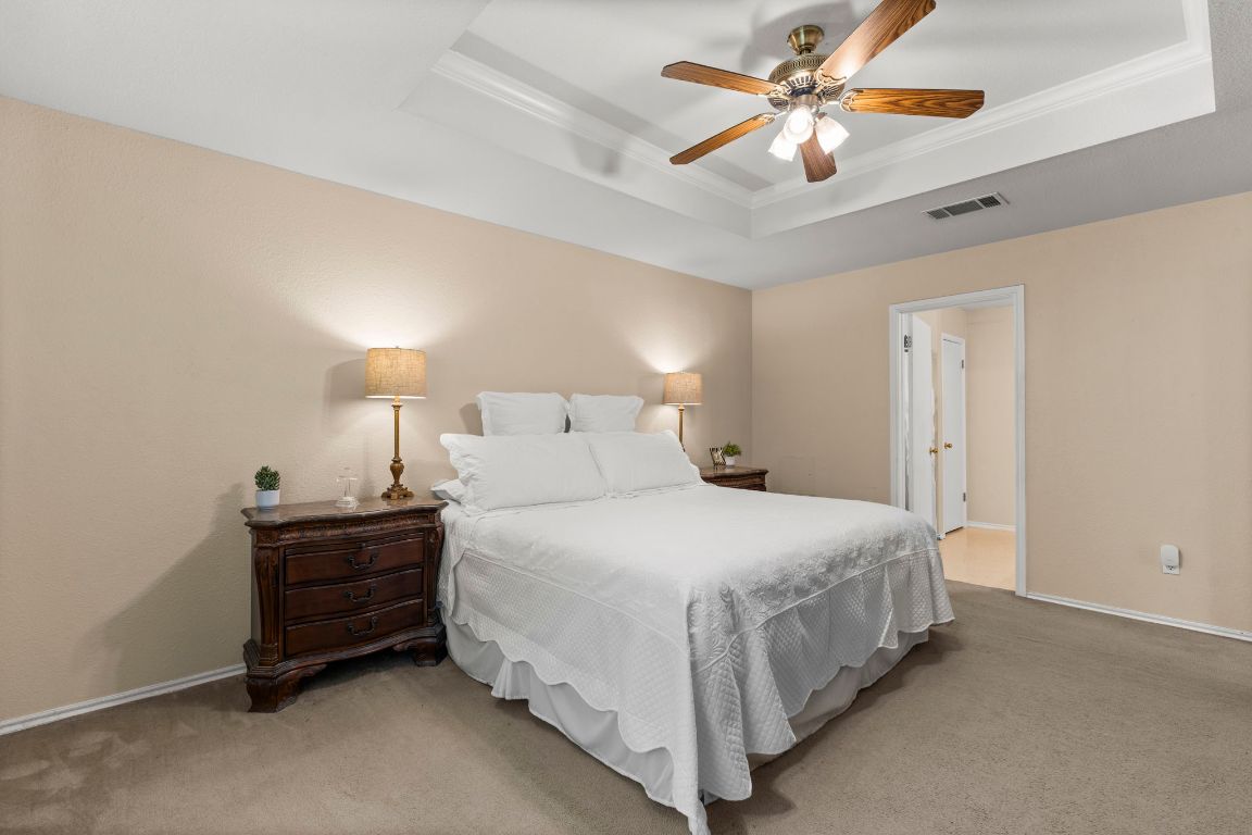 141 Sydney's Way Buda, TX 78610 - Photo 18 of 37 a bedroom with a bed and a chandelier