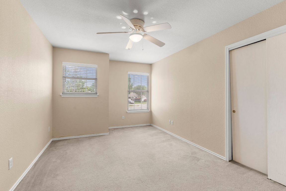 141 Sydney's Way Buda, TX 78610 - Photo 27 of 37 an empty room with windows and ceiling fan