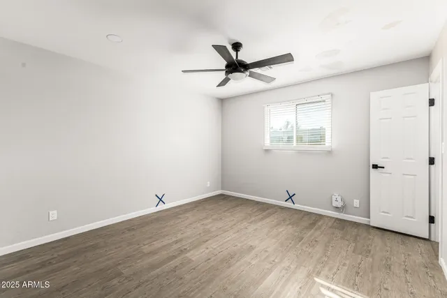 an empty room with a window and ceiling fan
