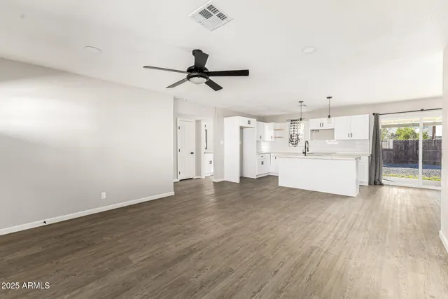 a view of a kitchen with wooden floor and windows