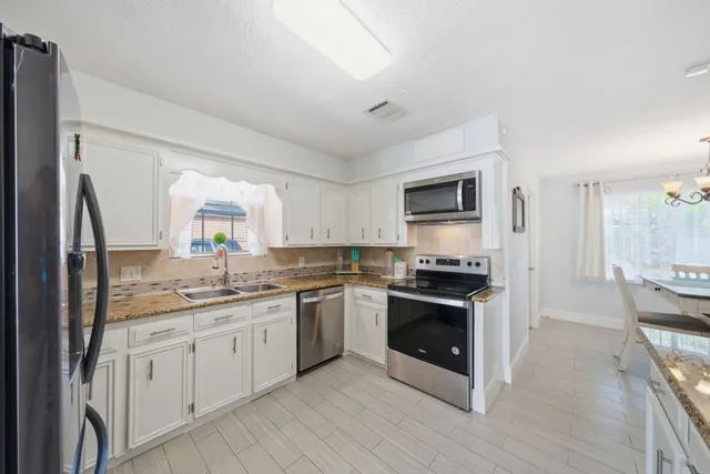 a kitchen with stainless steel appliances granite countertop a stove top oven a sink and dishwasher