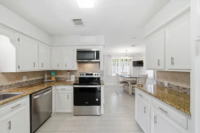 a kitchen with stainless steel appliances a stove sink microwave and cabinets