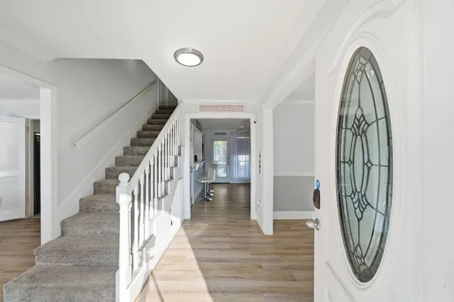 a view of a hallway with wooden floor and entryway