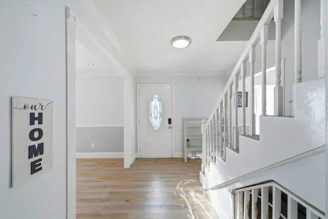 a view of entryway and hall with wooden floor
