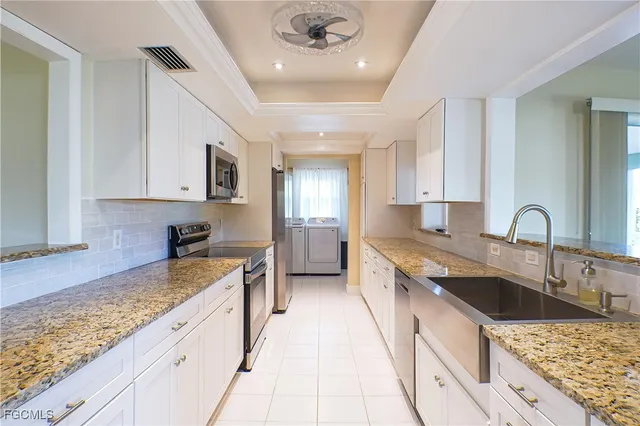 a kitchen with granite countertop a sink stove and cabinets