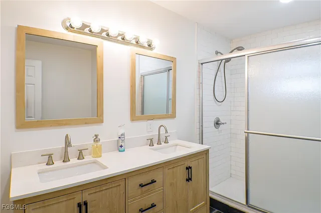 a bathroom with a granite countertop sink mirror and a shower