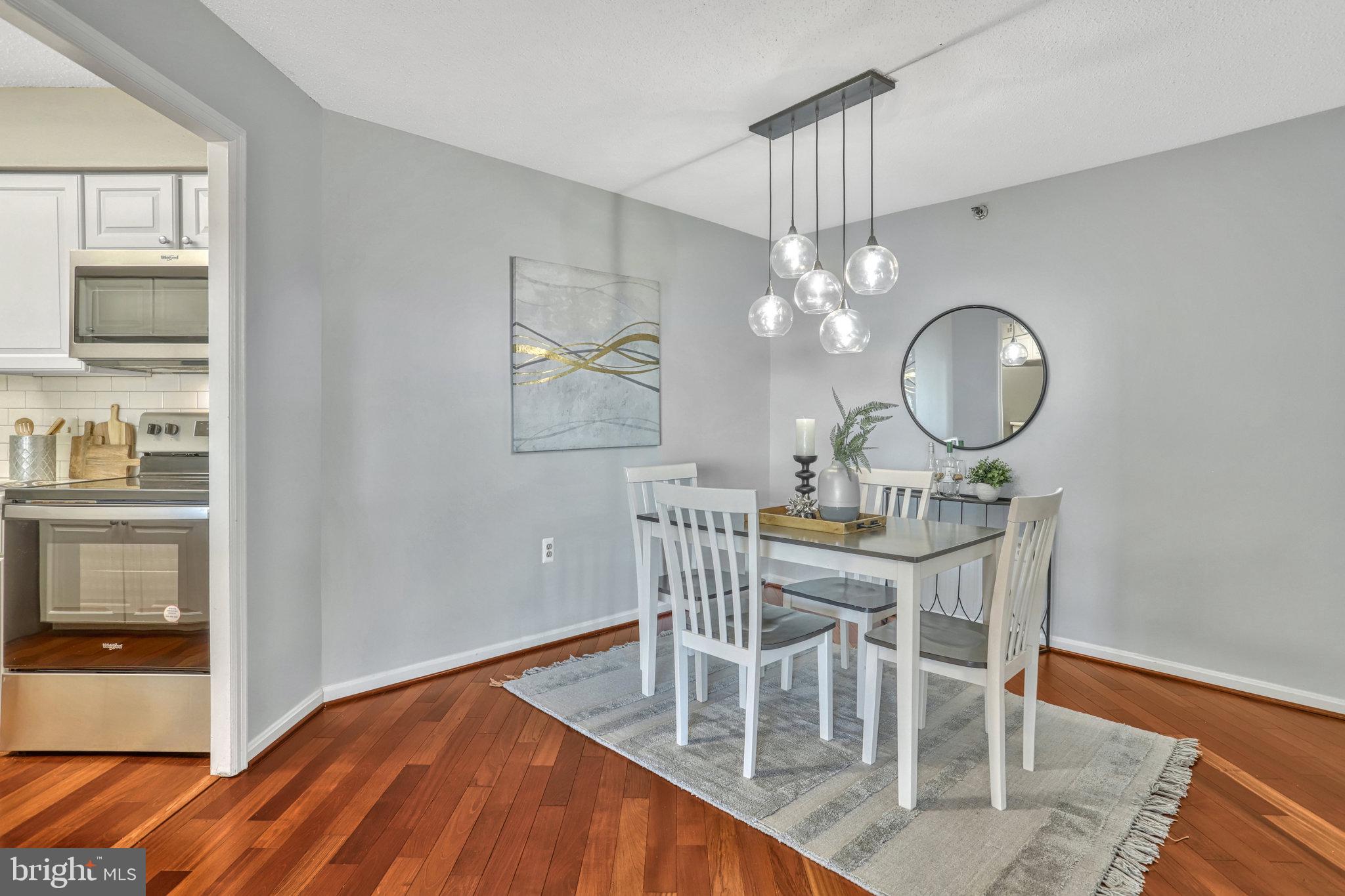1301 North Courthouse Road, Unit 1610 Arlington, VA 22201 - Photo 13 of 41 a view of a dining room with furniture a chandelier and wooden floor