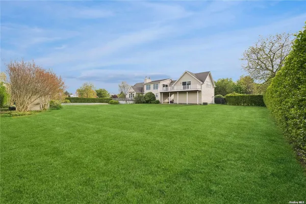 a view of a house with a big yard and large trees