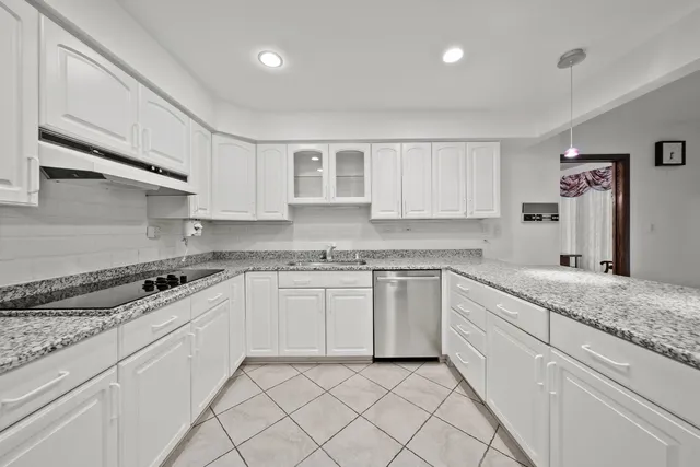 a kitchen with granite countertop white cabinets and white appliances