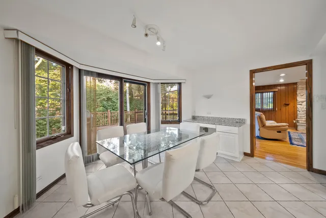a dining room with stainless steel appliances granite countertop a refrigerator and a sink