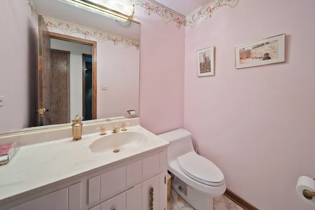 a bathroom with a sink vanity mirror and toilet