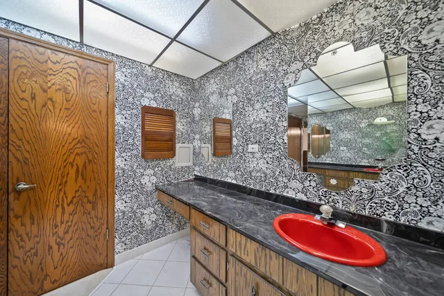 a bathroom with a granite countertop sink and a mirror