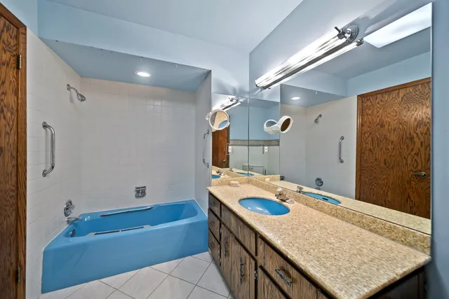 a bathroom with a granite countertop sink a toilet a mirror and shower