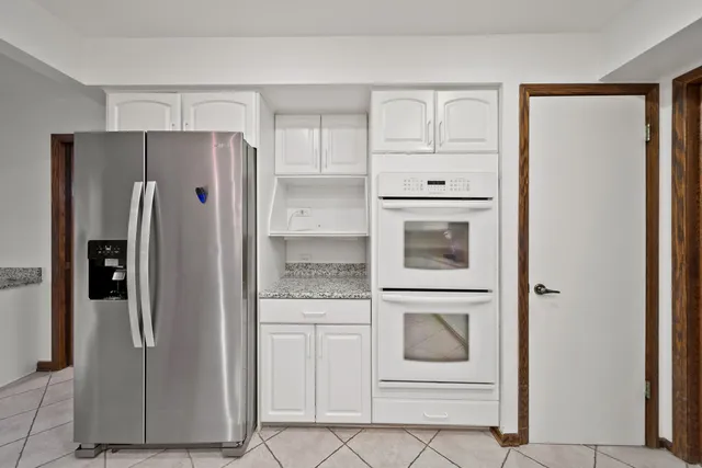 a kitchen with white cabinets and stainless steel appliances